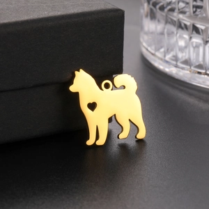 Close-up of golden dog silhouette pendant with hollow heart on matte metal finish