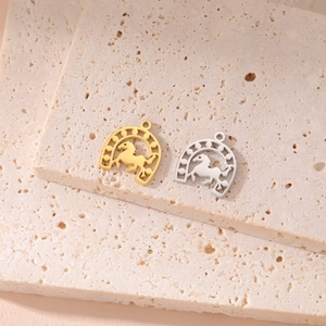 Detailed macro of 18K gold and silver horseshoe pendants with engraved horse patterns