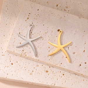 Polished starfish pendants in gold and silver steel finish on stone background