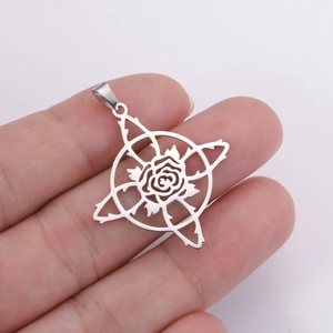 Macro shot of stainless steel rose pendant with gothic thorns held by hand