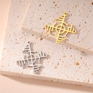 Macro shot of gold and silver Nordic rune star pendants on a natural stone surface