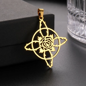 Detail of a gold stainless steel rose cross pendant with mirror finish on a black box