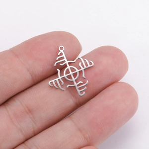 Macro shot of silver windmill geometric pendant held in fingers for size comparison