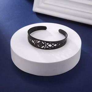 Dettaglio del ritaglio del nodo celtico nero opaco sull'ampio bracciale in acciaio inox