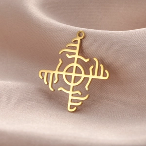 Macro view of gold stainless steel windmill pendant on elegant satin fabric