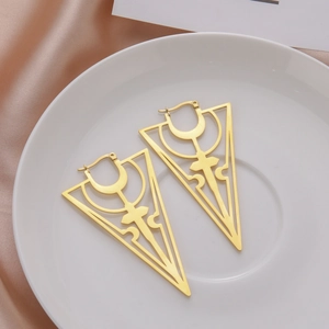 18K gold-plated Gothic hollow cross triangle earrings on white ceramic dish