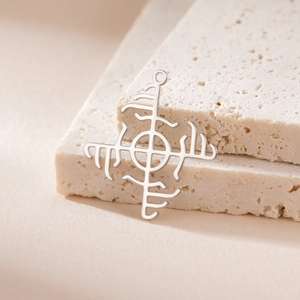 Macro shot of a silver Viking rune pendant placed on elegant beige travertine stone