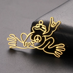 Dettaglio macro del ciondolo rana della pace placcato oro 18K con design traforato minimo