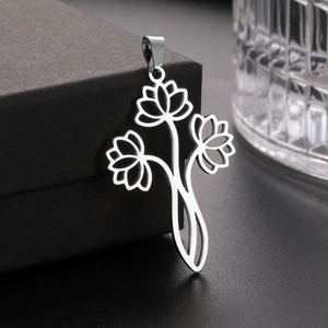 Macro shot of silver cutout triple lotus flower pendant on black jewelry box