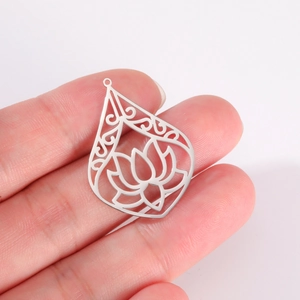 Macro shot of a silver teardrop lotus charm with detailed hollow carvings for DIY jewelry