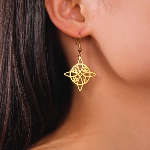 Boucles d'oreilles nœud celtique dorées avec pentacle et ankh portées par un mannequin
