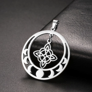 Macro shot of silver metal pendant with lunar moon phases and a Celtic knot center