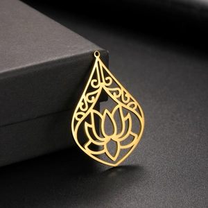 Macro detail of gold lotus hollow teardrop pendant on a black jewelry gift box