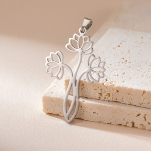 Macro detail of silver hollow lotus pendant on natural stone texture background