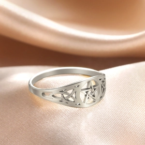 Macro shot of silver stainless steel ring featuring cutout pentagram and celtic knot