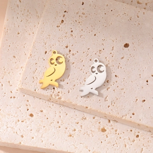 Minimalist gold and silver owl pendants on travertine stone for DIY jewelry making