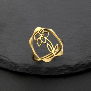Détail macro d'une bague florale ajourée en acier inoxydable plaqué or 18k sur pierre