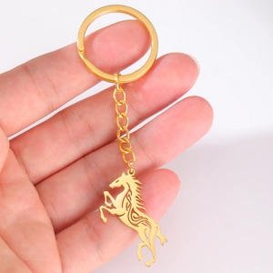 Close-up of golden stainless steel Celtic horse pendant keychain held in hand