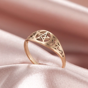 Vintage gold hollow pentagram ring with celtic knot details on pink silk background
