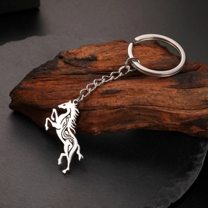 Detail of silver Celtic horse keychain featuring tribal cutout patterns on dark stone