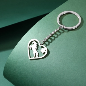 Détail d'un porte-clés cœur argenté avec découpe licorne sur fond texturé élégant