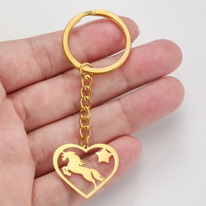 Porte-clés en acier inoxydable doré avec pendentif cœur licorne tenu à la main