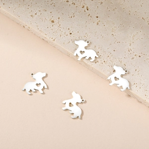 Macro shot of silver dachshund puppy pendants with heart cutouts for jewelry making