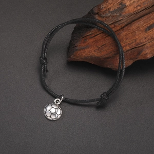Detailed close-up of adjustable soccer charm bracelet with silver football on black cord