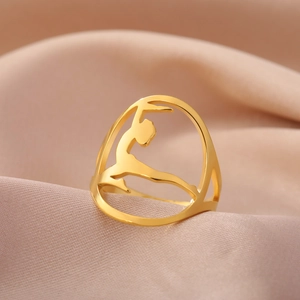 Close-up of golden hollow ring featuring a ballet dancer silhouette on pink silk