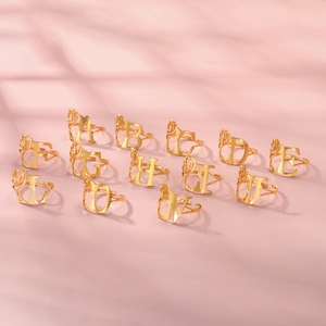 Golden hollow silhouette initial rings for women featuring profile portrait and tulips