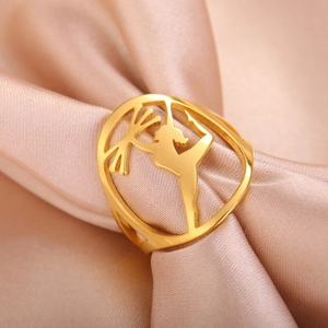 Artistic gold gymnastics athlete silhouette cutout ring on soft silk background