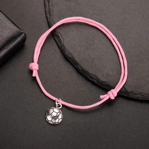 Close-up of bright pink braided soccer bracelet with adjustable cord and silver ball charm
