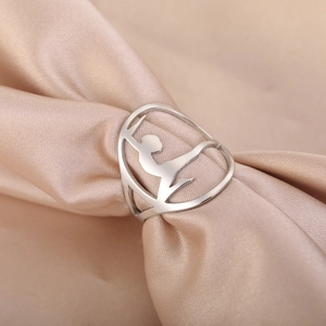 Hollow out gymnast silhouette ring in silver stainless steel on champagne satin fabric