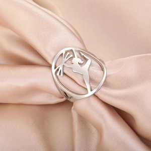 Polished stainless steel gymnast ring with hollow silhouette on elegant silk background