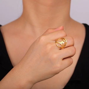 Detailed view of a gold cutout hummingbird ring worn on a finger for a stylish fit