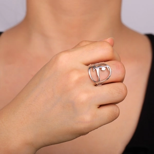 Close-up of a silver stainless steel ring featuring a hollow gymnast silhouette on a finger