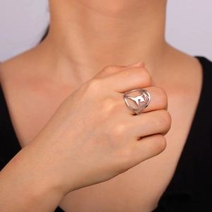Minimalist silver stainless steel ring with hollow yoga pose design on a model's finger