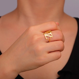 Detailed close-up of a gold hollow portrait ring worn on a finger for a stylish look