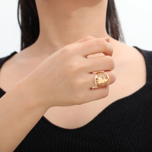 Gouden roestvrijstalen ring met uitgesneden ontwerp gedragen door een vrouwelijk model