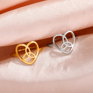 Minimalist stainless steel Celtic heart rings in gold and silver on silk fabric