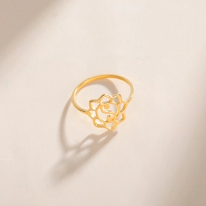 Macro detail of gold lotus ring featuring cutout Tai Chi Yin Yang symbol and floral edges