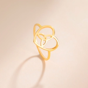 Detailed view of golden heart ring featuring an intricate Celtic triquetra knot design
