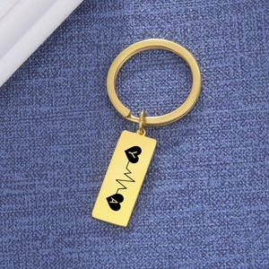 Macro detail of custom gold stainless steel keychain with ECG heart and letters Y and A