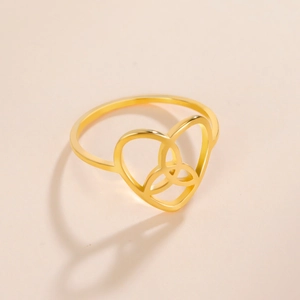 Detailed view of golden stainless steel Celtic knot heart ring on minimalist background