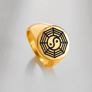 Dettaglio di un anello a sigillo in acciaio dorato con simboli Bagua e Tai Chi smaltati