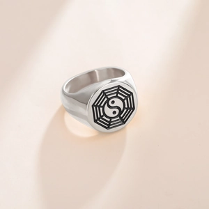 Dettaglio macro dell'anello da uomo in acciaio con simbolo Tai Chi Yin Yang nero inciso