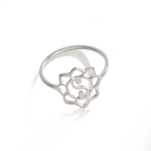 Macro detail of silver stainless steel ring with hollow lotus and tai chi yin yang design
