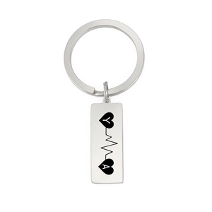 Detailed engraving of heart symbols and heartbeat line on a silver rectangle keychain