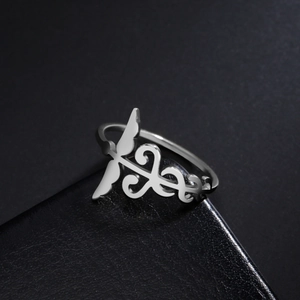Bague en acier inoxydable poli avec un design de caducée sur un écrin en cuir noir