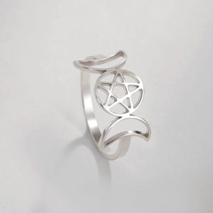 Vista macro de anillo de acero inoxidable con pentagrama calado y motivos de luna creciente